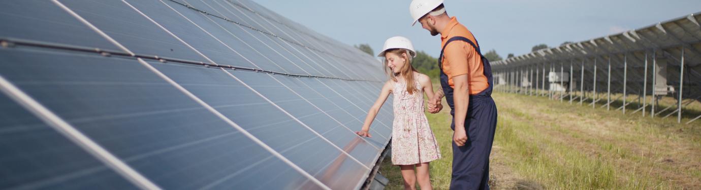 man and girl looking at solar panel