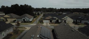 View of a roof in a neighborhood with black solar panels